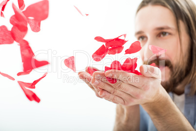 Man blowing paper hearts