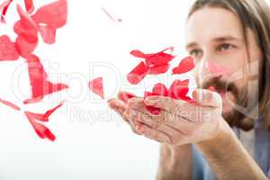 Man blowing paper hearts