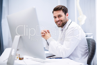 Portrait of male doctor sitting at desk