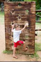 Boy climbing on a playground ride in park