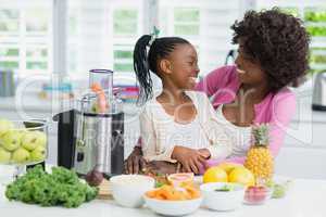 Mother and daughter interacting in kitchen at home