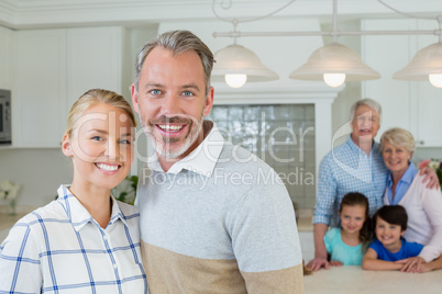 Portrait of happy couple standing at kitchen