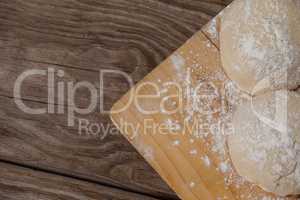 Pizza dough and flour on chopping board