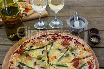 Italian pizza served with wine glasses and ingredients