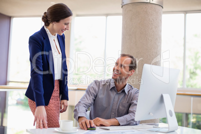 Businessman interacting with colleague at desk