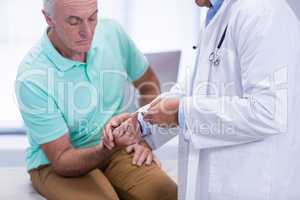 Doctor examining senior patient blood sugar
