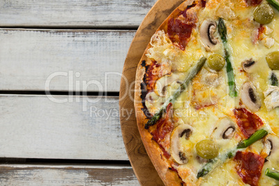 Italian pizza in a chopping board on a wooden plank