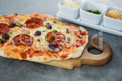 Italian pizza served with ingredients on a chopping board
