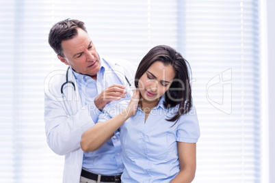Female patient showing neck pain to doctor