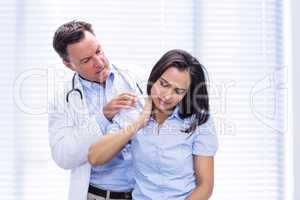 Female patient showing neck pain to doctor