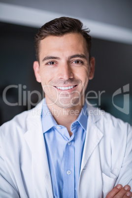 Portrait of smiling doctor standing with arms crossed