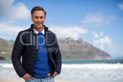 Smiling mature man standing on the beach