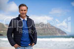 Smiling mature man standing on the beach