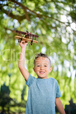 Portrait of boy playing with a toy aeroplane in park