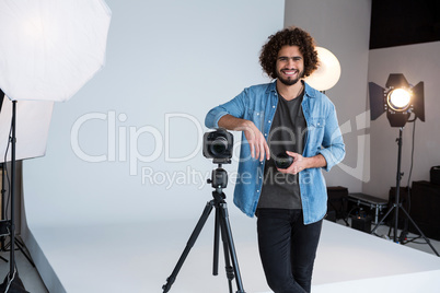 Happy male photographer standing in studio