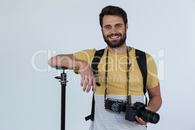 Happy male photographer with digital camera in studio