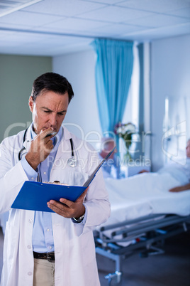 Thoughtful male doctor looking at medical report