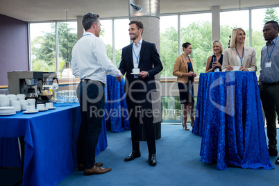 Business executives interacting with each other while having coffee