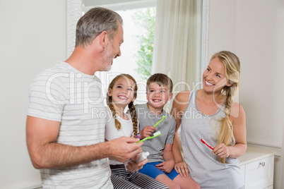 Parents and kids interacting with each other while brushing teeth in bathroom