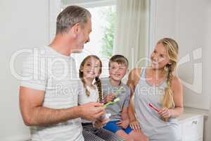 Parents and kids interacting with each other while brushing teeth in bathroom