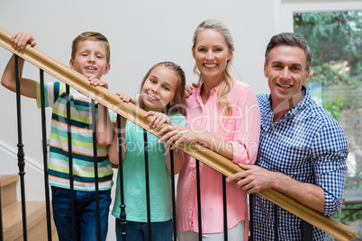 Parents and kids standing in staircase at home