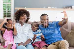 Happy family taking a selfie from mobile phone in living room