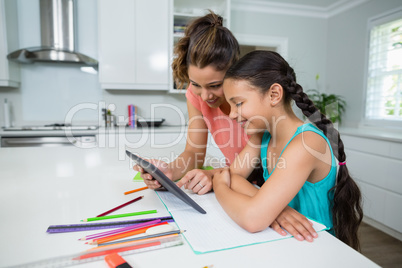 Mother and daughter using digital tablet