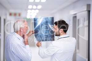Doctor discussing x-ray with patient in corridor