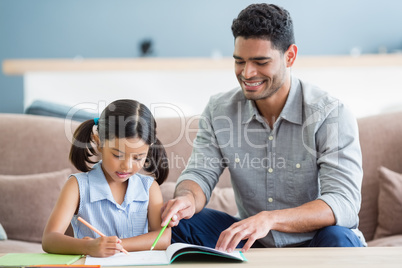 Father assisting her daughter in doing her homework