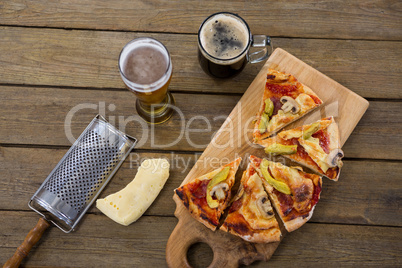 Italian pizza served on a chopping board with a beer mug and glass