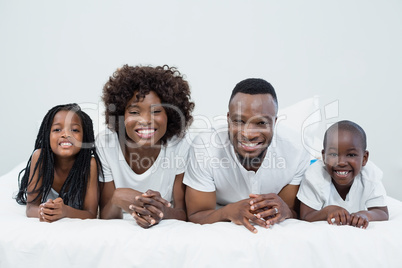 Portrait of parents and kids lying on bed