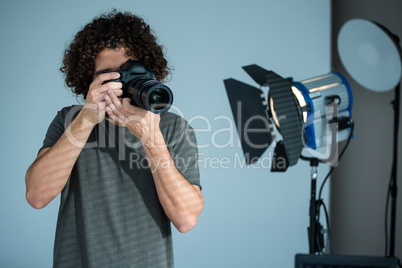Male photographer with digital camera in studio