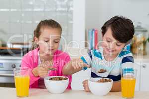 Siblings having a breakfast in kitchen