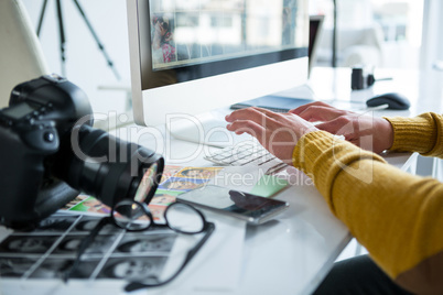 Male photographer working over computer at desk