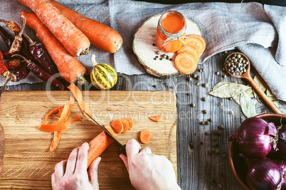 Two female hands chopped fresh carrot slices