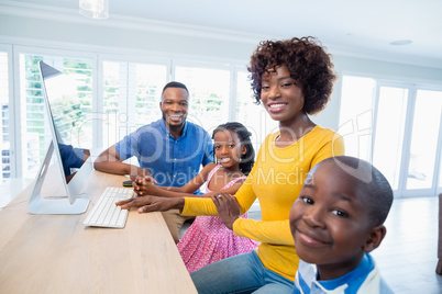 Happy family using computer in living room at home