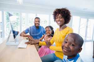 Happy family using computer in living room at home