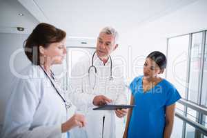 Nurse and doctors discussing over digital tablet