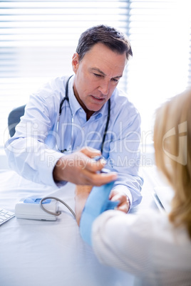 Doctor checking blood pressure of a patient