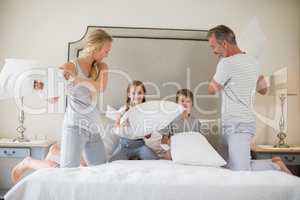 Cute family having a pillow fight in bedroom