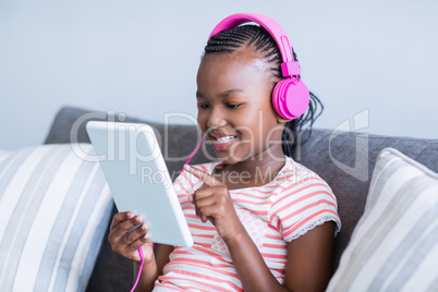 Girl listening to music from digital tablet