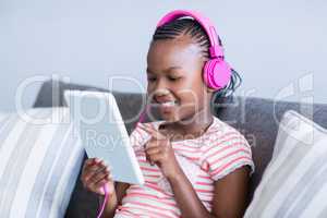 Girl listening to music from digital tablet