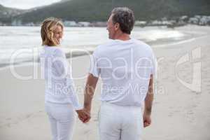 Couple standing with holding hands on the beach