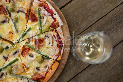 Italian pizza served on a pizza tray with a glass of wine