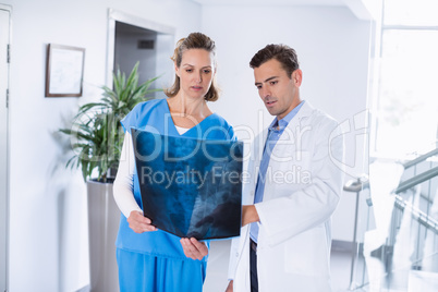 Two doctors looking over patients x-ray in corridor