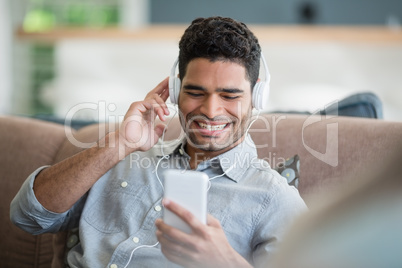 Man listening to music on mobile phone in living room