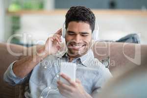 Man listening to music on mobile phone in living room