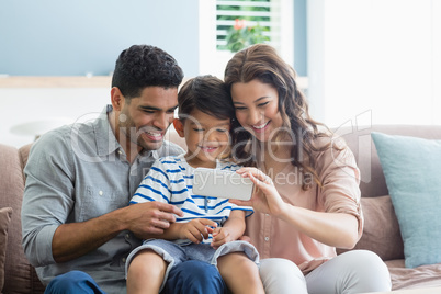 Parents and son checking photos in mobile phone