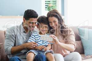 Parents and son checking photos in mobile phone
