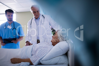 Doctors comforting senior patient on bed